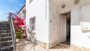 Un bâtiment blanc avec un escalier en pierre et une porte blanche.