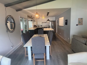 Enjoy a spacious living area with a dining table, sofa, and large mirror.