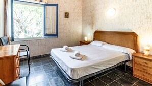 Une chambre d’hôtel comprenant un lit, des tables de chevet, un bureau et une chaise.