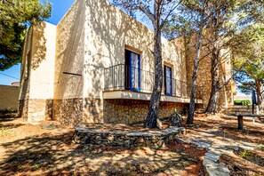 A traditional stone building with a balcony and a stone staircase leading to the entrance. - Grifeu 14 - Apartment with terrace and garden (Llança)