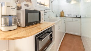 Keittiössä on kahvinkeitin, mikroaaltouuni, leivänpaahdin, uuni ja pesuallas.