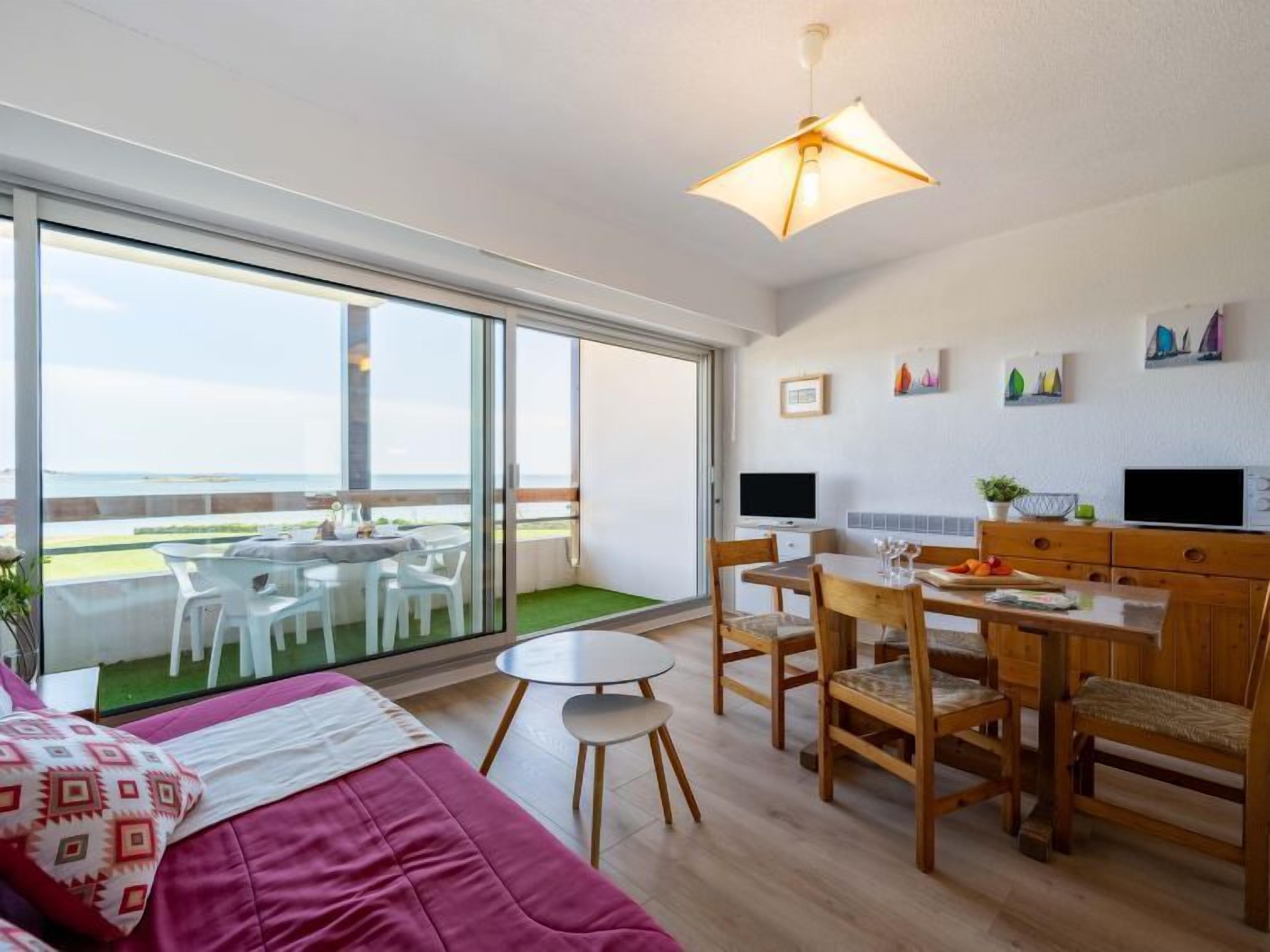 Une chambre moderne dotée d’un lit, d’un coin repas et d’un balcon avec vue.