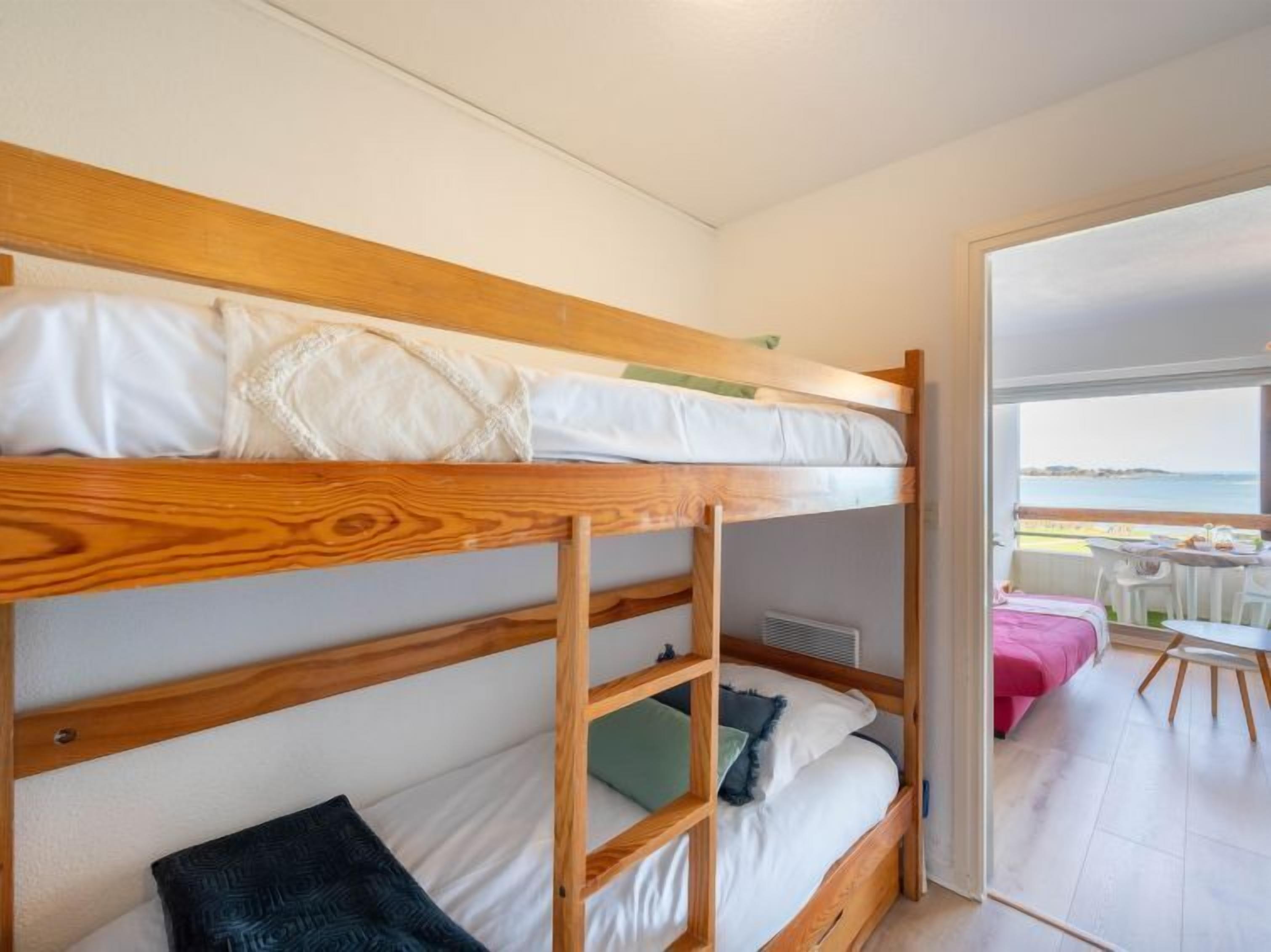 A bunk bed room with a view of the sea.