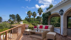 A terrace with a pool, outdoor seating, and a view of the surrounding greenery. - Villa Bellavista by Interhome (Jávea)