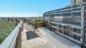 A wooden deck with a sign instructing to remove sand before entering the pool. - Summerhouse #1205A- DIRECT BEACH FRONT, RECENTLY RENOVATED, GREAT LOCATION! (Orange Beach)