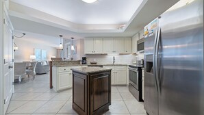 A modern kitchen with a central island, stainless steel appliances, and light-colored cabinetry. - Summerhouse #1205A- DIRECT BEACH FRONT, RECENTLY RENOVATED, GREAT LOCATION! (Orange Beach)
