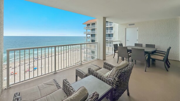 A balcony with a view of the beach, wicker furniture, and a dining area. - Summerhouse #1205A- DIRECT BEACH FRONT, RECENTLY RENOVATED, GREAT LOCATION! (Orange Beach)