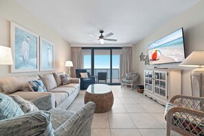 A living room with a sofa, chairs, a coffee table, a television, and artwork on the wall. - Summerhouse #1205A- DIRECT BEACH FRONT, RECENTLY RENOVATED, GREAT LOCATION! (Orange Beach)