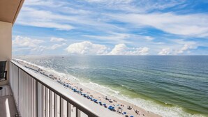 A balcony with a view of a beach and ocean.