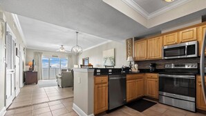 A modern kitchen with wooden cabinets, stainless steel appliances, and a central island.