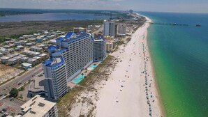 Ein Küstenhotel mit mehreren Hochhäusern, einem Strand und einem Steg.
