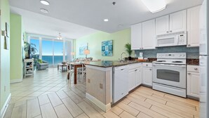 A modern kitchen with white cabinets, a dishwasher, a microwave, and an oven.