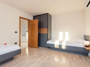 A modern hotel room with two beds, a wardrobe, and a large window. - Villa Julia by Interhome (Buje)