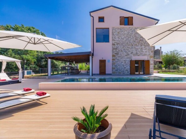 A modern house with a swimming pool, outdoor seating, and a covered patio. - Villa Julia by Interhome (Buje)