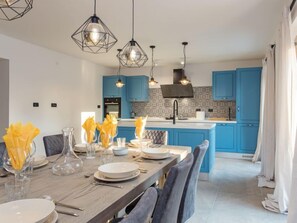 A modern kitchen with blue cabinets, a central island, and pendant lighting. - Villa Julia by Interhome (Buje)
