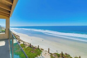 A beach view from a balcony with clear skies and ocean waves. - Oceanfront Luxury Condo w/ Hot Tub & Pool (Solana Beach)