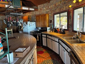 A kitchen with a brick wall, wooden cabinets, a stove, and a sink. - Beautiful and incredibly stocked turn key Oceanfront Casa for 6. (San Felipe)