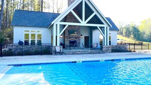 Une maison avec une piscine, une cheminée en pierre et un espace extérieur aménagé pour se détendre.