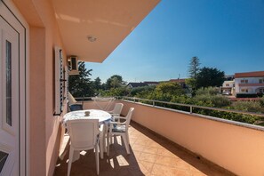 Enjoy a quiet moment on the balcony with a small table and four chairs.