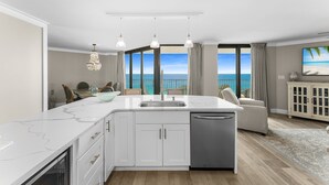 A modern kitchen with a large island, a dishwasher, and a view of the ocean. - EXQUISITE!  GULF FRONT~5th Floor~ Specials ~ Free Beach Service! Completely Remodeled (Panama City Beach)