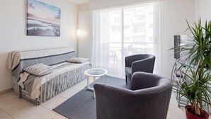 A modern living room with a sofa, two armchairs, a small round table, and a potted plant. - L'Hippocampe T2 avec Balcon by Interhome (Les Sables d'Olonne)
