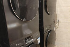 Una lavandería comercial con lavadoras industriales y un panel de control.