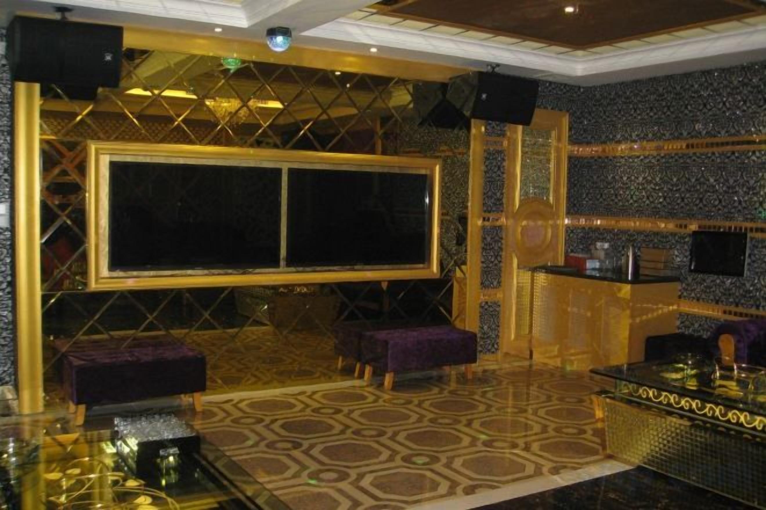 Una habitación con un ventanal grande, una zona de bar y un suelo estampado.