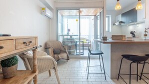 Una cocina moderna con una mesa de comedor de madera, dos taburetes de bar y una encimera de cocina.