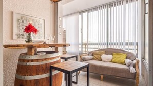 Un espacio de sala acogedor con un barril de madera, un sofá con cojines y una mesa.