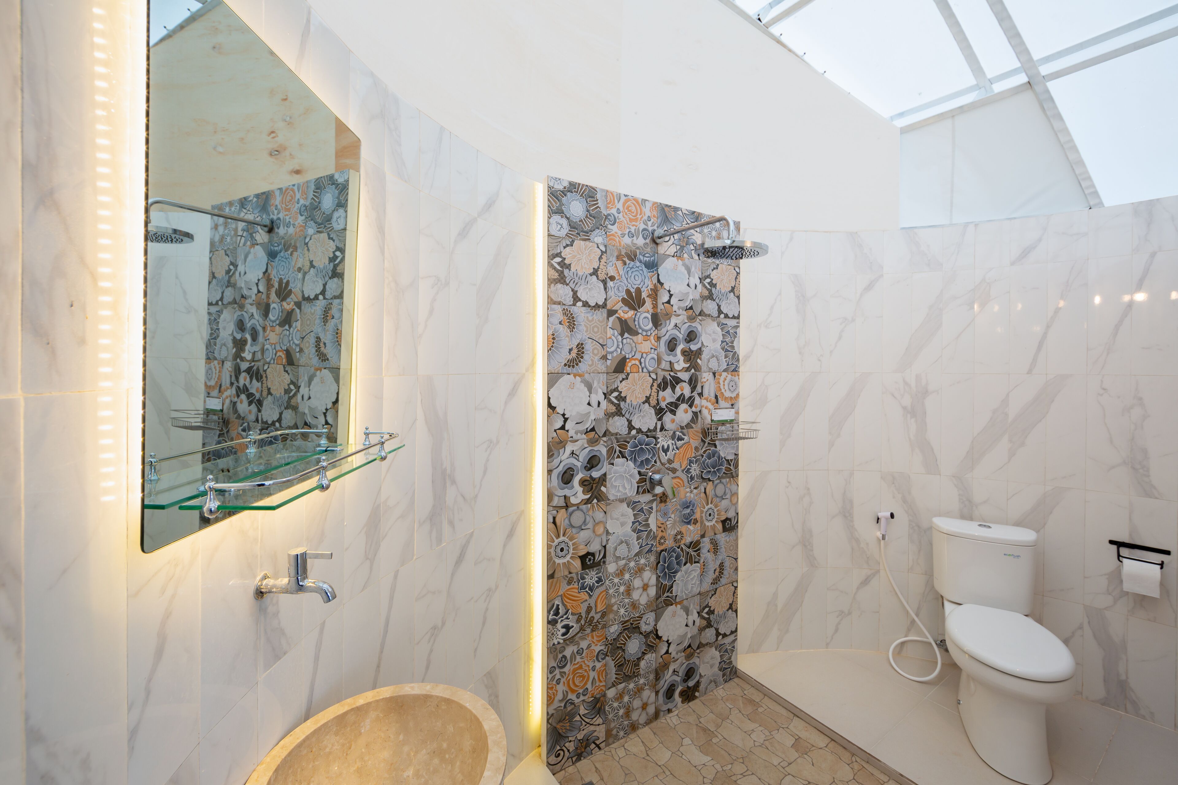 Ein modernes Badezimmer mit Duschkabine aus Glas, Marmorfliesen und Toilette.