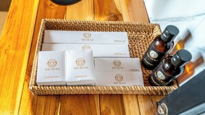 A wooden tray with dental and sanitary kits, a shower cap, and bottles of shampoo. - The Dewi Kintamani (Kintamani)