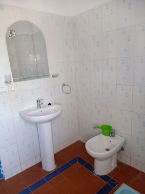 Un baño con lavamanos blanco, un espejo y un inodoro.