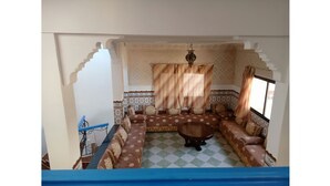 A room with a patterned sofa set, a small round table, and a patterned rug.