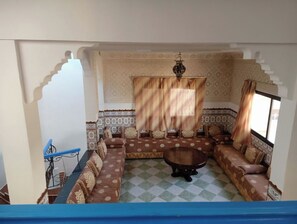 A room with a patterned sofa set, a small round table, and a patterned rug. - Villa 2 apartment holandi (Lkser sghir)