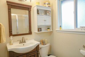 A bathroom with a white sink, a mirror, a toilet, and a window with a view of the outside. - Pet friendly w/dog run, country living & mountain views close to town with wifi (Springfield)