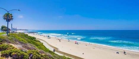 Ranta lähistöllä, aurinkotuoleja, rantapyyhkeitä