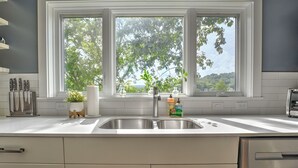A kitchen with a large window, stainless steel sink, and modern appliances. - Northshore Chattanooga - Hot Tub - Walk to Dining, Publix & Coolidge Park (Chattanooga)