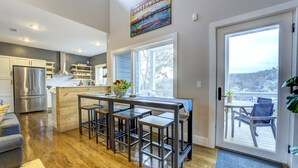 A modern kitchen with a central island, stainless steel appliances, and a large window overlooking a deck. - Northshore Chattanooga - Hot Tub - Walk to Dining, Publix & Coolidge Park (Chattanooga)