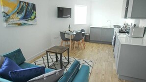 A modern apartment with a dining area, kitchen, and living room.