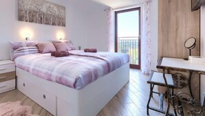 Une chambre à coucher avec un lit, des tables de chevet, un bureau et un balcon.