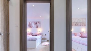 Une chambre à coucher avec un grand lit, des tables de chevet et une commode.
