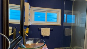 A bathroom with a wooden vanity, a glass bowl sink, a mirror, and a shower area. - Casa Moon in best neighborhood! (Utila)