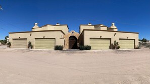 A two-story building with a central entrance, two garages, and a stone facade.