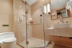 A modern bathroom with a glass-enclosed shower, a white sink, and a toilet.