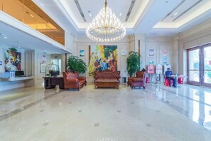 A spacious lobby with a chandelier, sofas, and potted plants. - Vienna International Hotel (Yongzhou Lingling Junyue Huacheng) (Yongzhou)