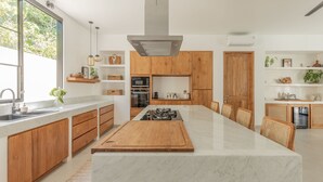 Una cocina moderna con una isla central, armarios de madera y un ventanal que proporciona luz natural.