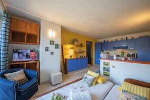 A living room with a sofa, a chair, a small table with a lamp, and a television. - Rebecca's House (few steps from skiing) (Bardonecchia)