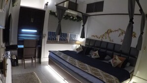 Un dormitorio con cama, mesita de noche y escritorio con silla.