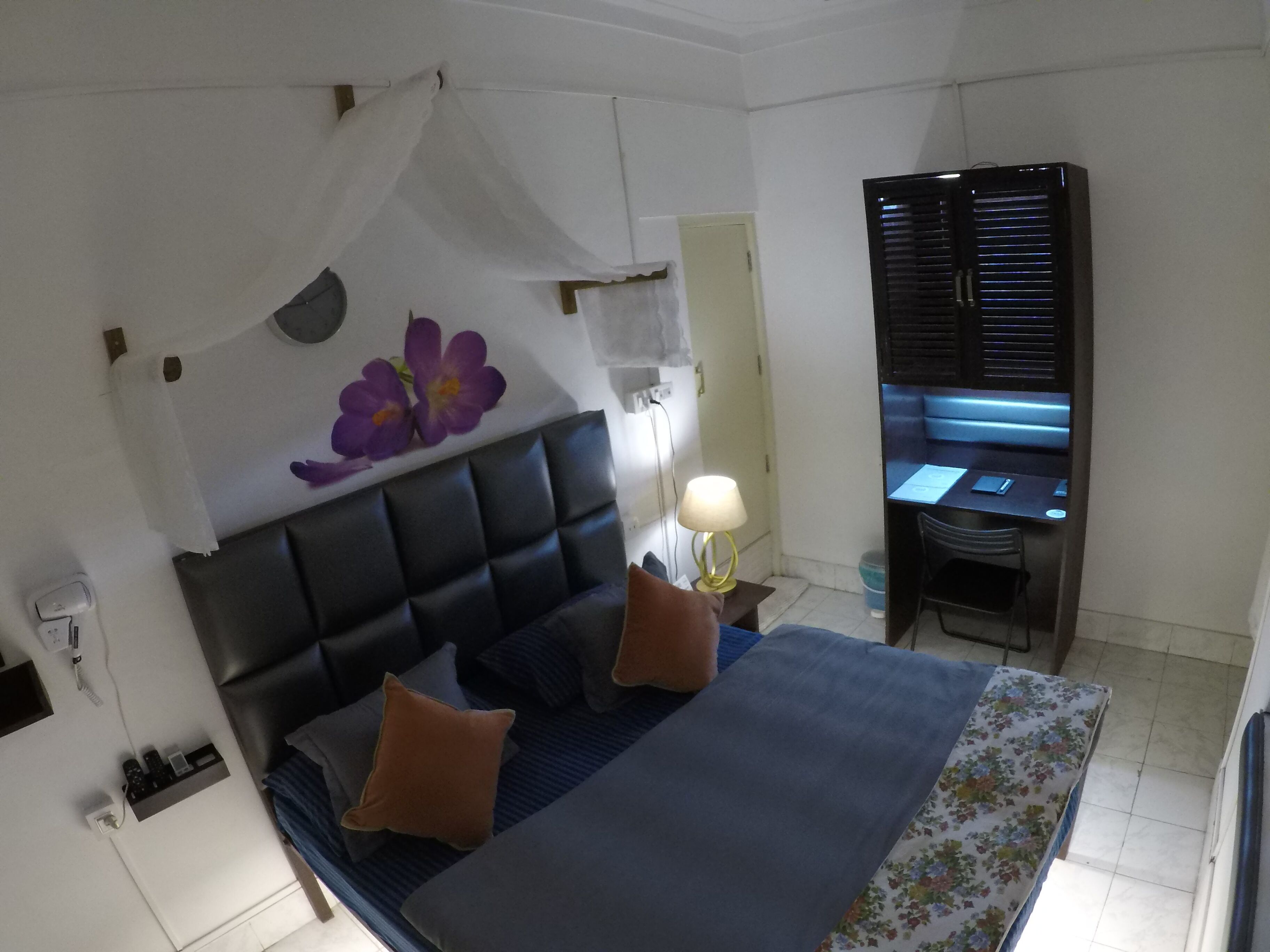 A bedroom with a bed, a desk, and a chair.