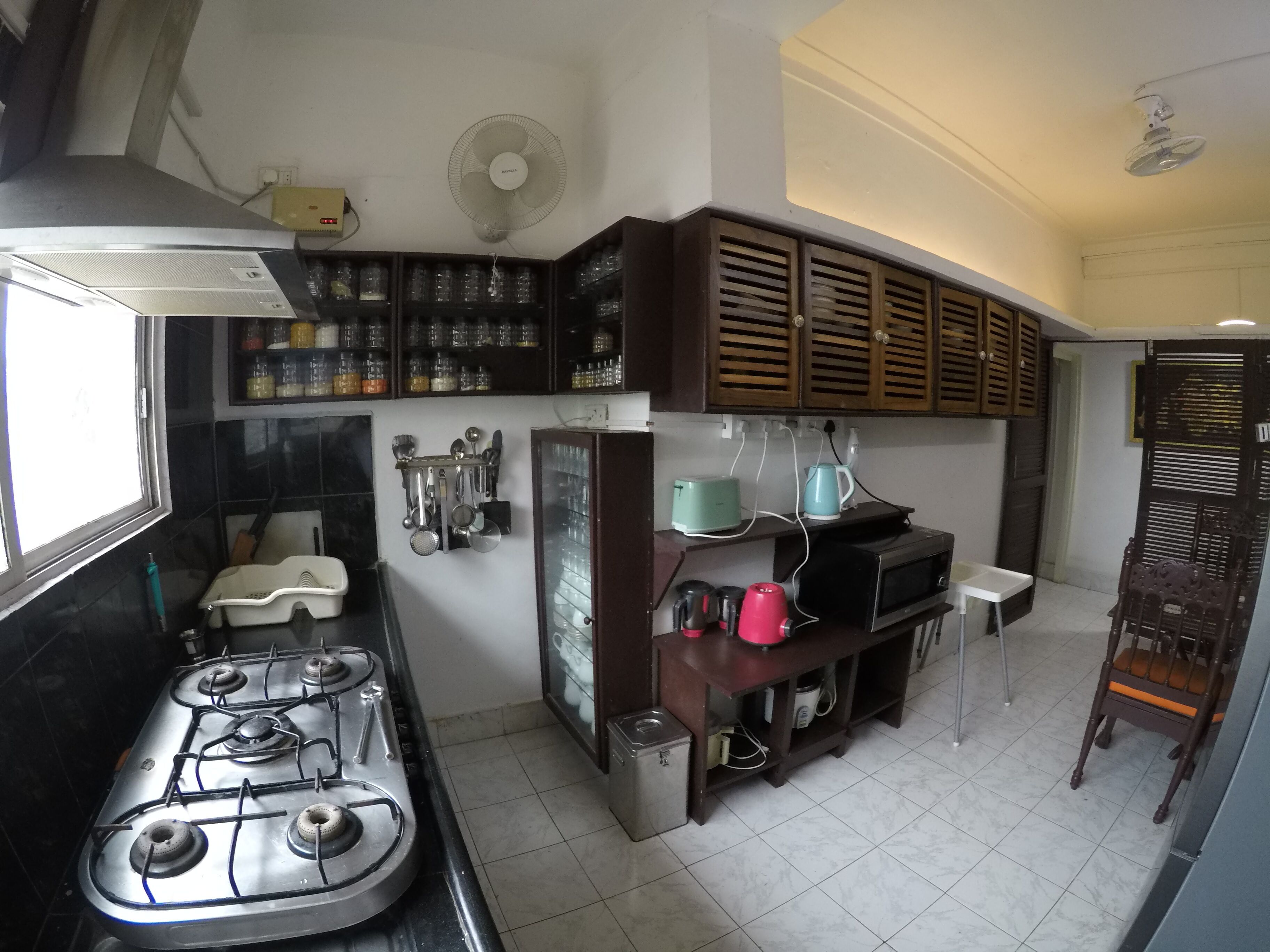 A kitchen with a gas stove, cabinets, a microwave, and various kitchen utensils.